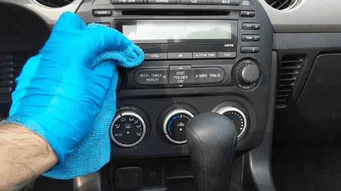 Image of hand with glove cleaning car interior