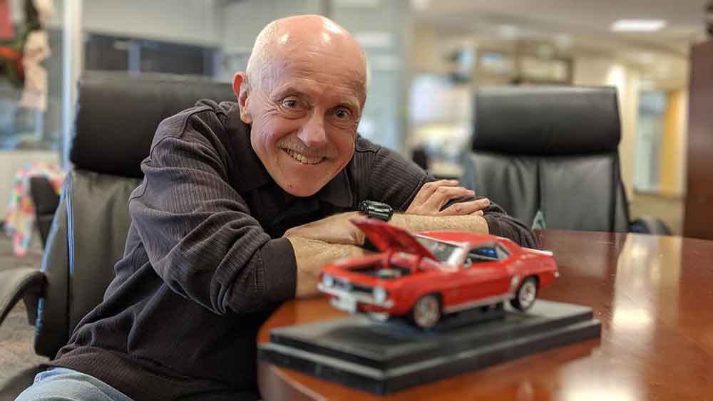 Interstate Expert Joe Semens holds a model car with the hood up.