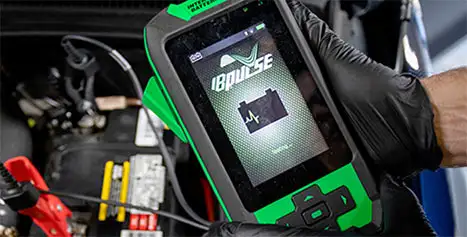 Technician performing a professional automotive battery diagnostic health test