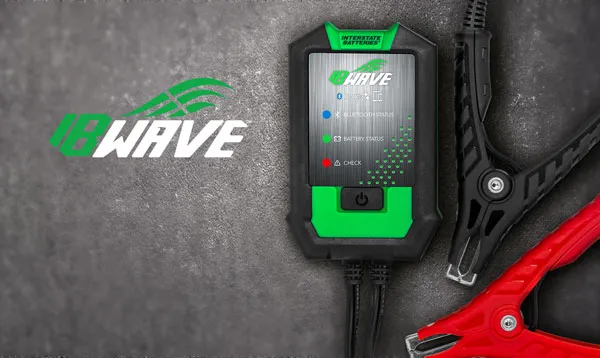 Tabletop studio display of the handheld Interstate Batteries Wave diagnostic tool and heavy-duty terminal clamps