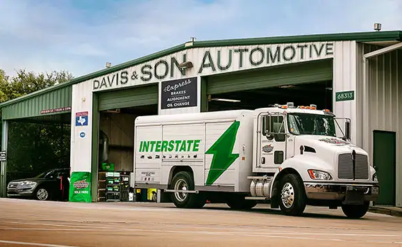 An automotive repair shop exterior featuring official Interstate Batteries authorized dealer storefront signage to attract local customers