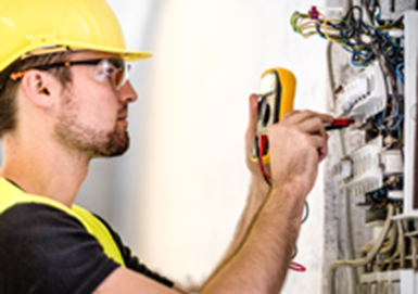 fire and security technician testing a circuit with a voltmeter