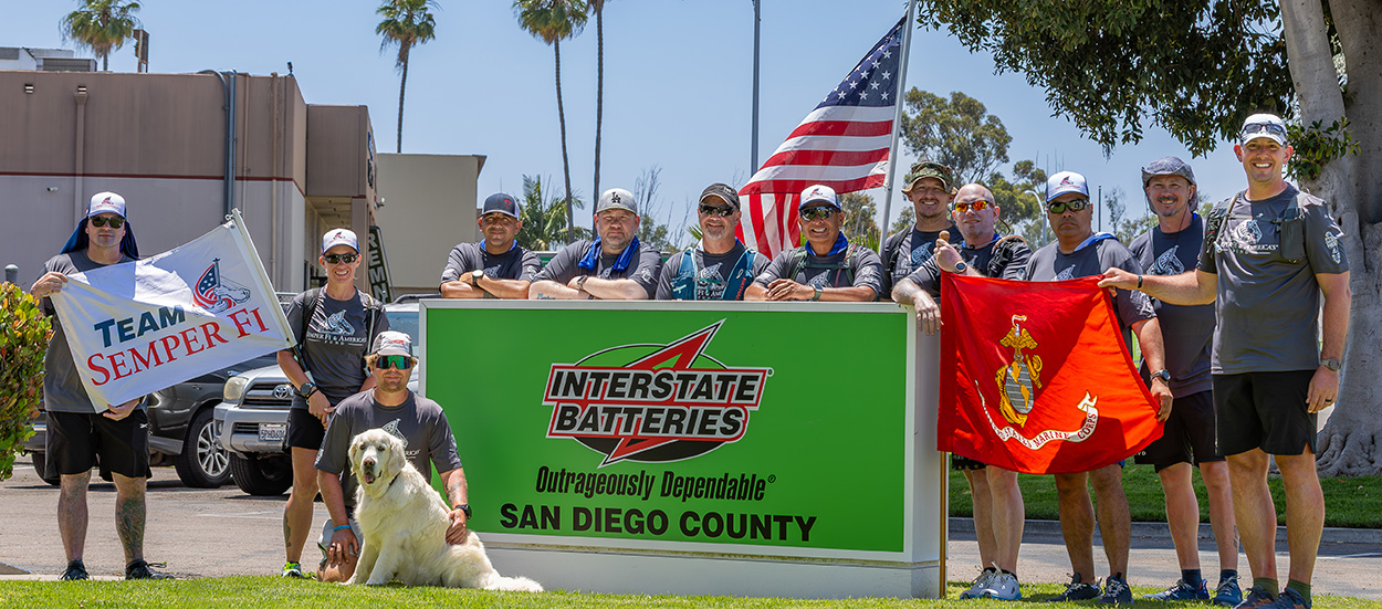Semper Fi team posing in front of Interstate Batteries sign