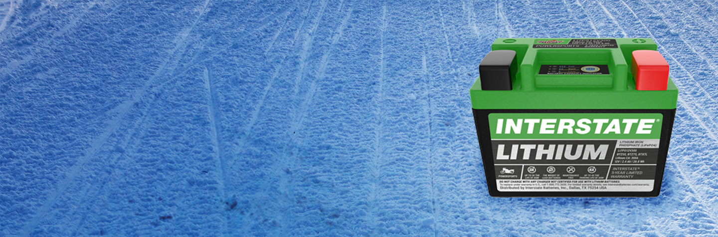 Lithium powersports battery sitting on snowy trail