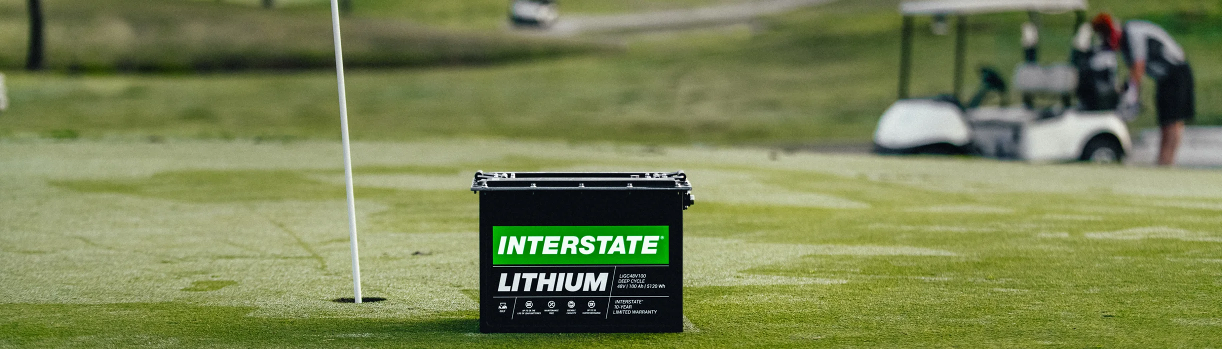lithium battery on golf course green with golf cart in background
