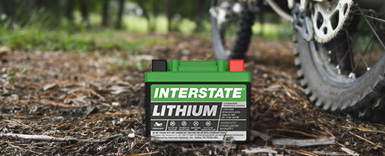 Lithium battery on the ground with dirtbike wheels to the right