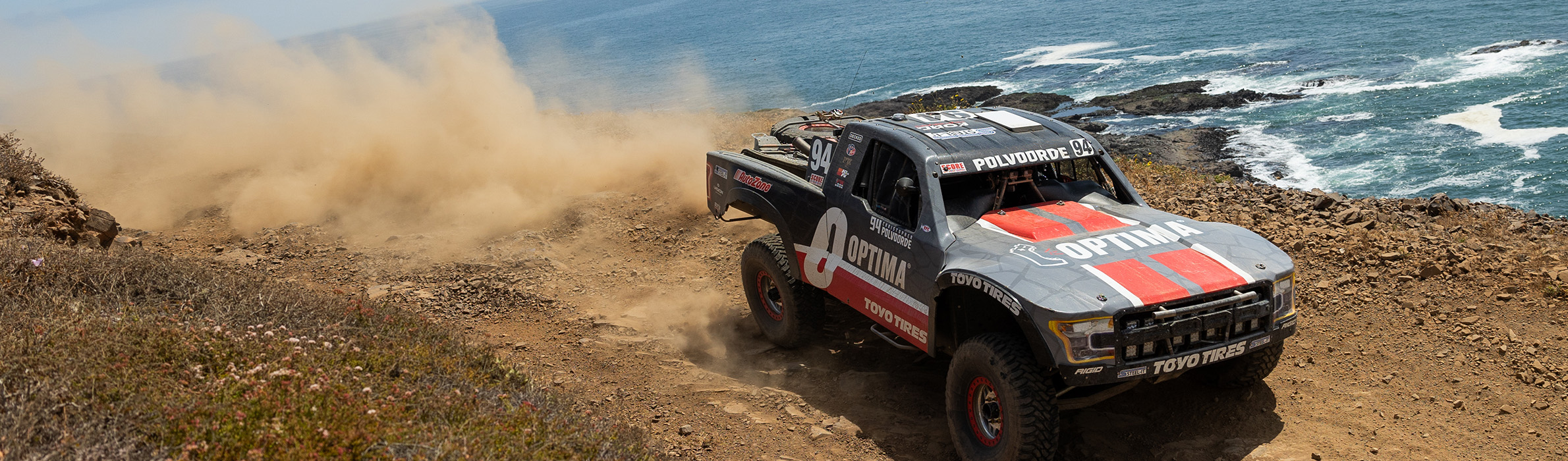 Optima truck driving alongside a beach