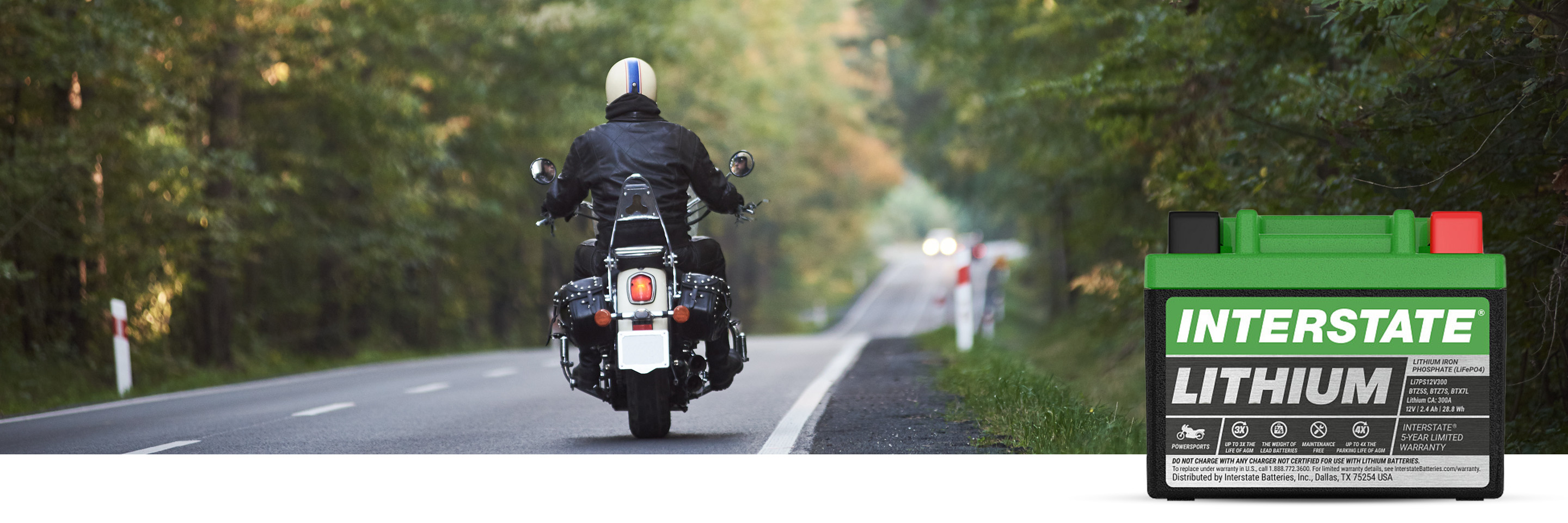 A person driving a motorcycle down a road with an Interstate lithium battery in bottom right corner