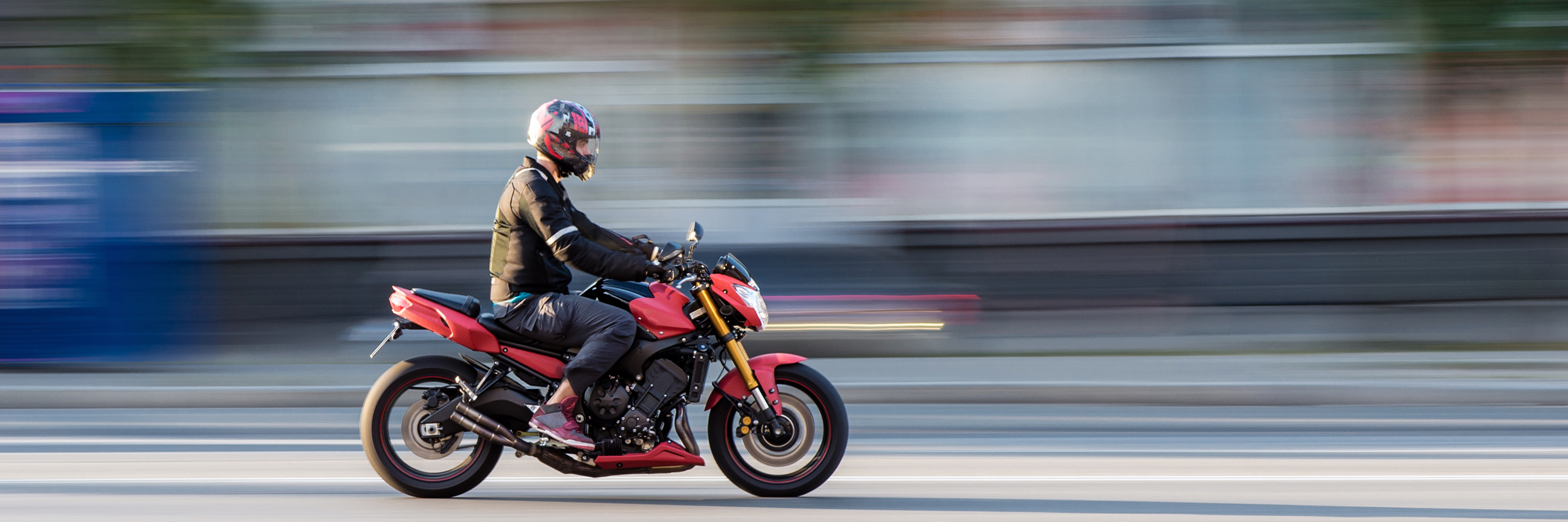 Person driving motorcycle on street in motion