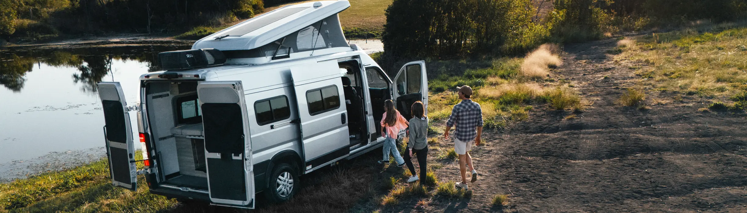 family getting in RV at a lake
