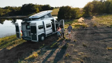 family getting in RV at a lake