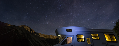 RV parked at night using batteries to power interior lights