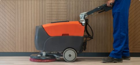 Janitor using floor scrubber