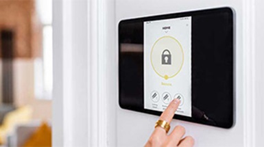 person pressing alarm system screen