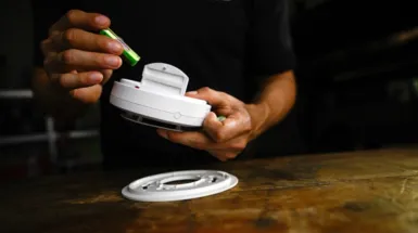 person pressing alarm system screen