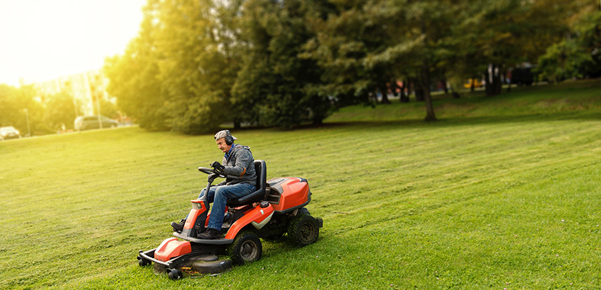 man mowing lawn on a riding lawn mower