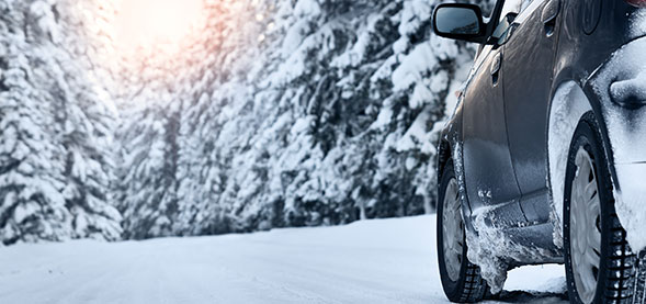 Car driving down snowy road