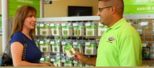 Interstate All Battery Center employee helping a customer choose battery products in a retail store