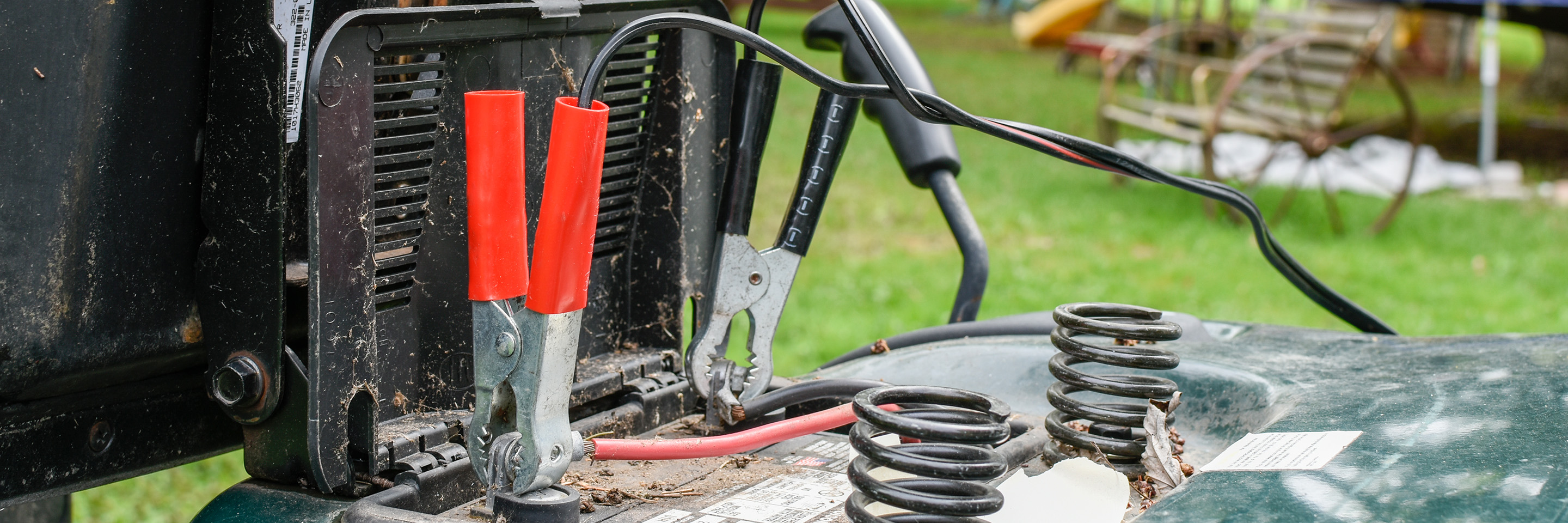 jumper cables attached to lawn mower battery