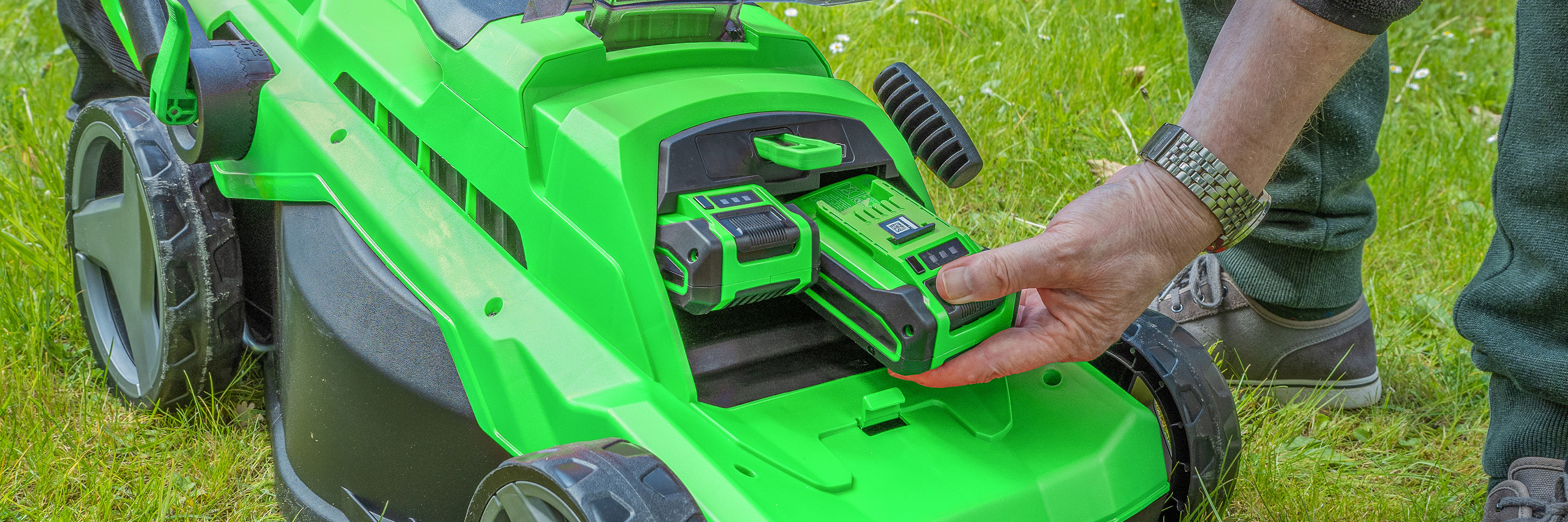 person using lawn mower battery charger