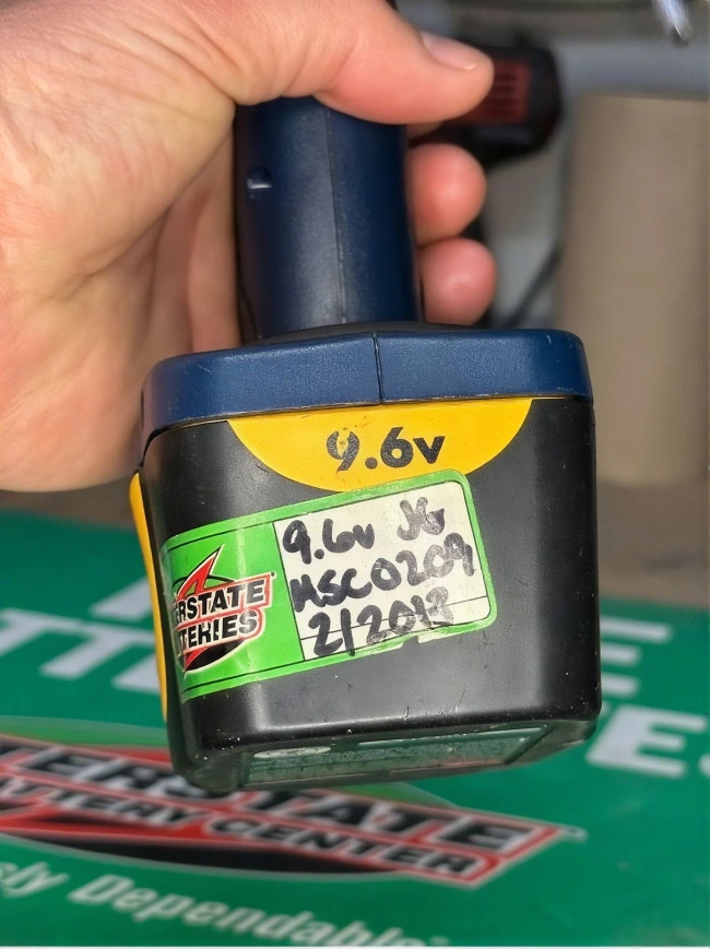 Dead Ryobi drill battery pack with original repair sticker from 2013