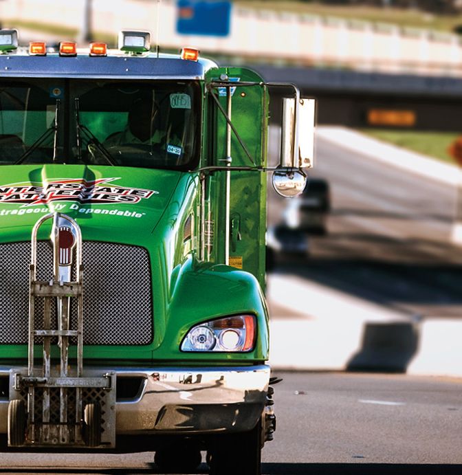 Interstate Batteries delivery truck driving on a city highway