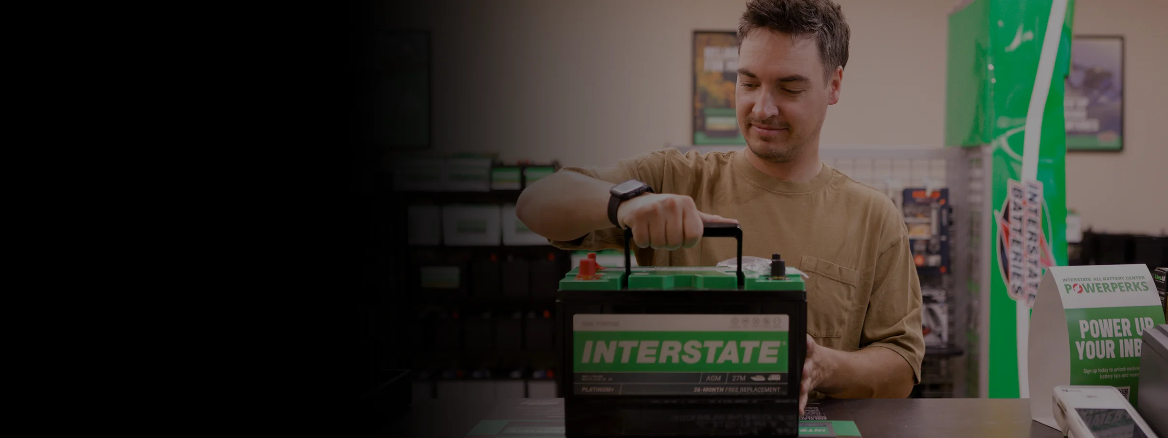 Customer picking up an Interstate Batteries automotive battery inside an Interstate All Battery Center